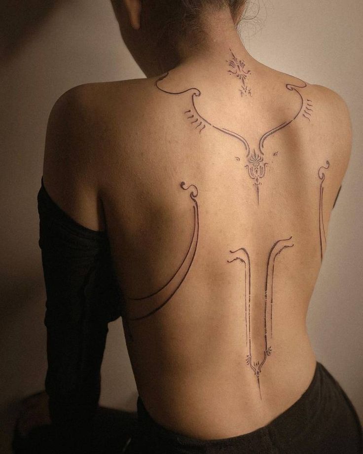 the back of a woman's body with tattoos on her upper and lower back