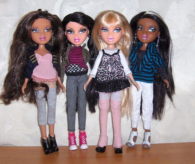 four dolls standing next to each other on a table