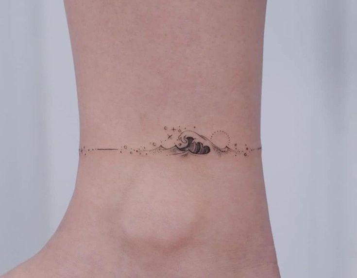 a woman's foot with a small wave tattoo on the side of her ankle