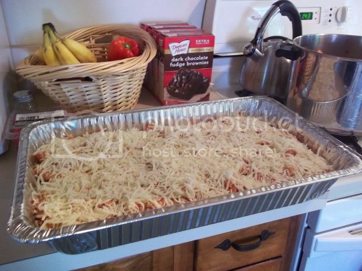 an uncooked casserole in a pan on top of a counter next to other cooking utensils