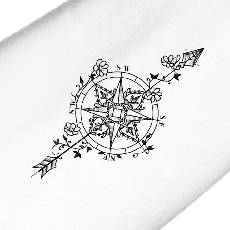 a black and white photo of a compass tattoo