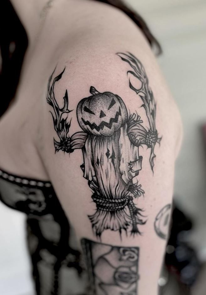 a woman with a tattoo on her arm has a scarecrow and pumpkin in it