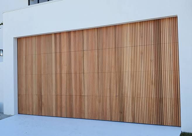 a large wooden garage door in front of a white building