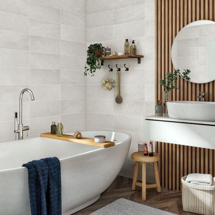 a white bath tub sitting under a bathroom mirror