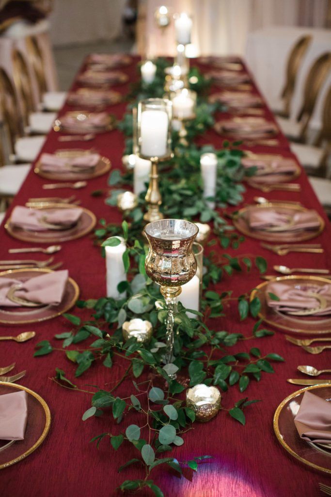 a long table with candles and greenery is set up for an elegant dinner party