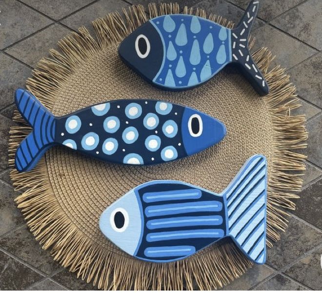 two blue and black fish sitting on top of a woven tablecloth next to each other