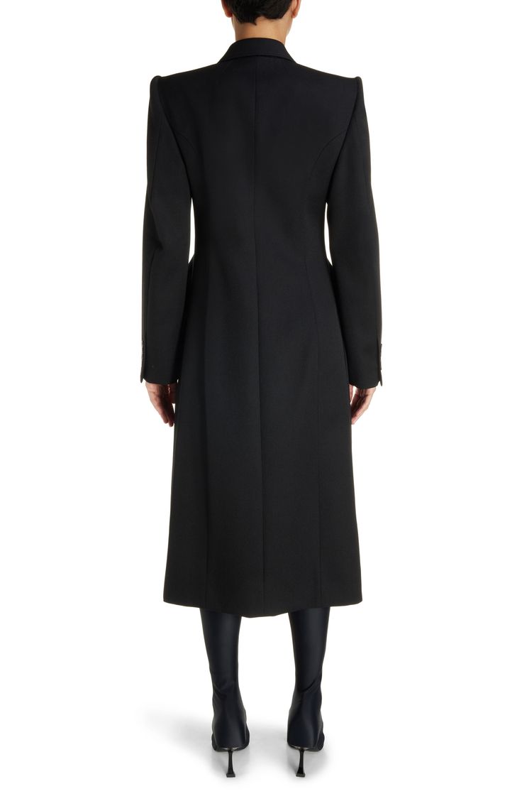 Demna revisits the iconic hourglass shape with this wool-gabardine coat channeling the exaggerated tailoring of master courtier Cristóbal Balenciaga. 48" length (size 38fr) Double-breasted button closure Peaked lapels Four-button cuffs Chest welt pocket; front flap pockets Cupro lining 100% wool Dry clean Made in Italy Designer Clothing Evening Wool Long Coat Single Breasted, Evening Single-breasted Long Wool Coat, Evening Long Single-breasted Wool Coat, Timeless Evening Outerwear With Hidden Button Closure, Timeless Structured Evening Outerwear, Tailored Evening Outerwear With Concealed Front Fastening, Tailored Wool Coat With Long Sleeves For Evening, Classic Structured Evening Outerwear, Elegant Black Outerwear With Structured Boning