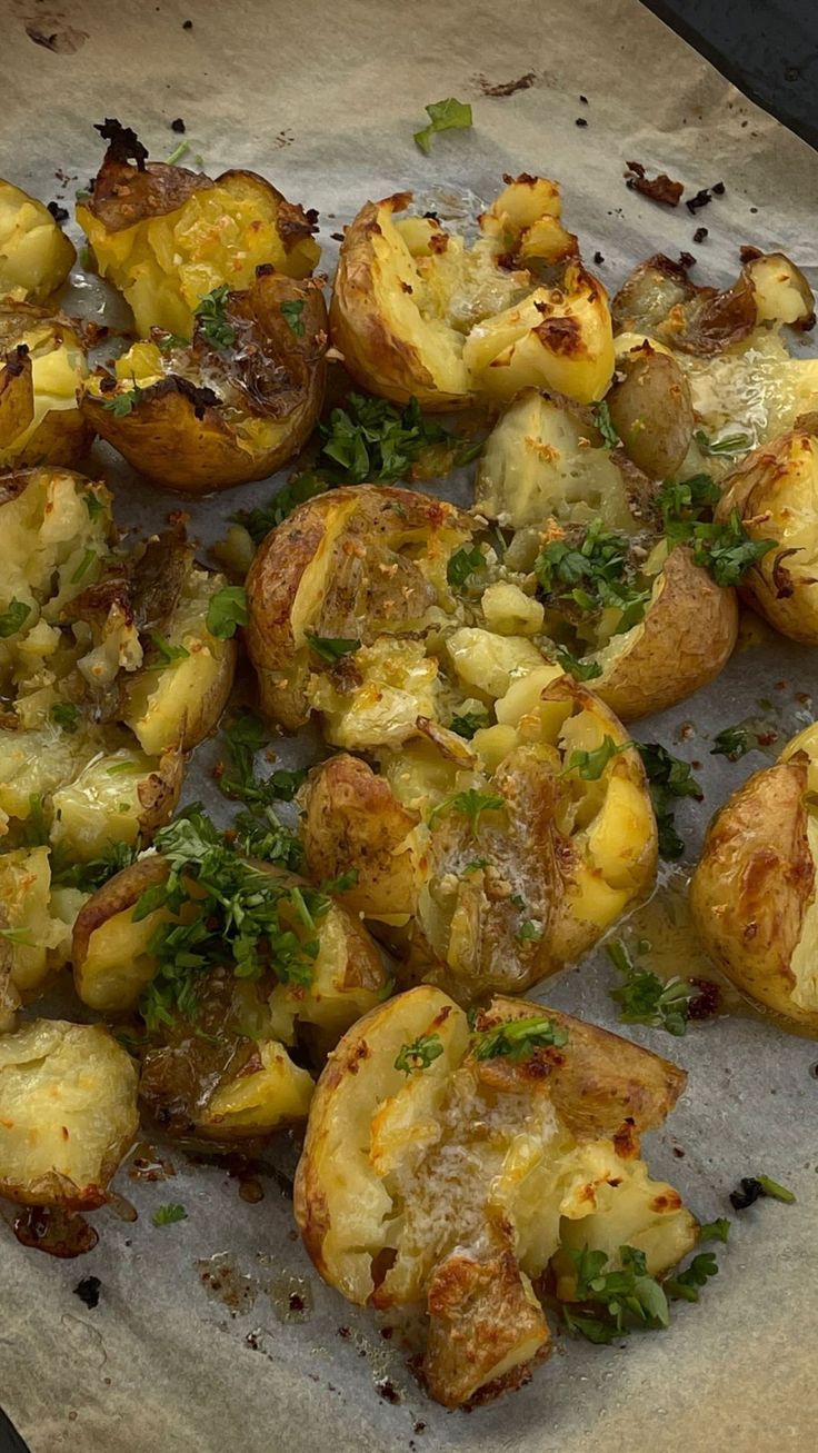 cooked potatoes with herbs and seasoning sitting on a baking sheet, ready to be eaten