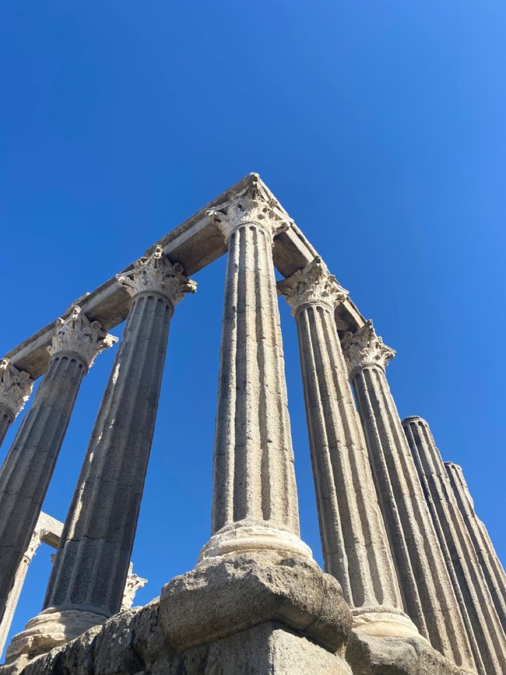 some very tall stone pillars against a blue sky