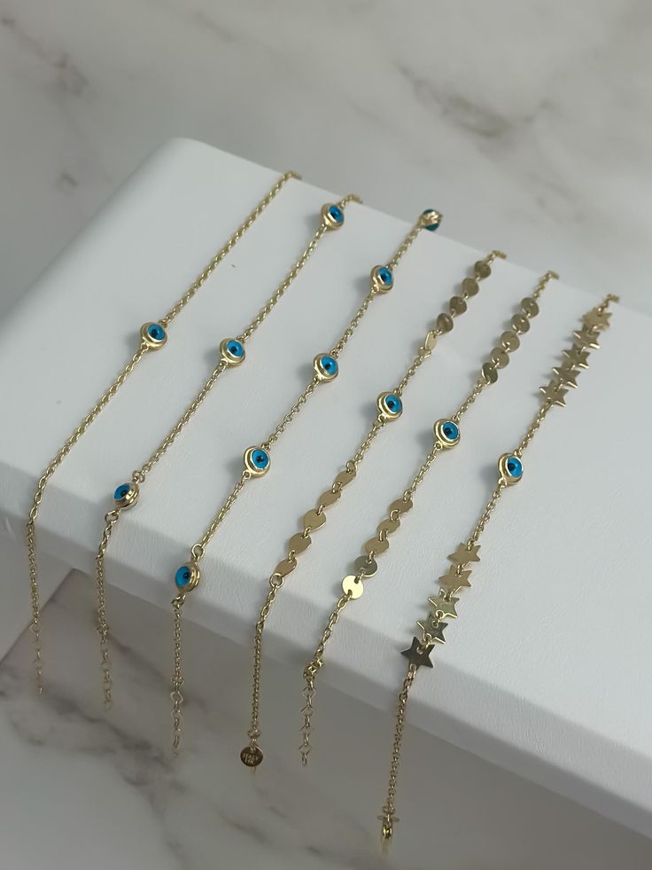 Explore our enchanting 14k Solid Gold Blue Evil Eye Bracelet Collection, where timeless elegance meets protective charm. Each bracelet in this collection features the iconic blue evil eye, a symbol believed to ward off negative energy and bring good fortune. Crafted from luxurious 14k solid gold, these bracelets offer a perfect blend of sophistication and durability P R O D U C T ∙ M E A S U R E M E N T S Bracelet 1: * 100% 14k Solid Gold * Length: Adjustable from 6 to 7 inches  * Weight: 1.6 gr Gold-plated Jewelry With Extender For Gifts, 14k Gold Bracelet With Extender As A Gift, Blue Dangle Jewelry With Adjustable Chain, Elegant Blue Bracelets With Adjustable Chain, 14k Gold Filled Evil Eye Jewelry, Elegant Blue Chain Bracelet As Gift, Elegant Blue Chain Bracelet For Gift, Blue Gold Plated Jewelry With Charms, Blue Gold-plated Jewelry With Charms