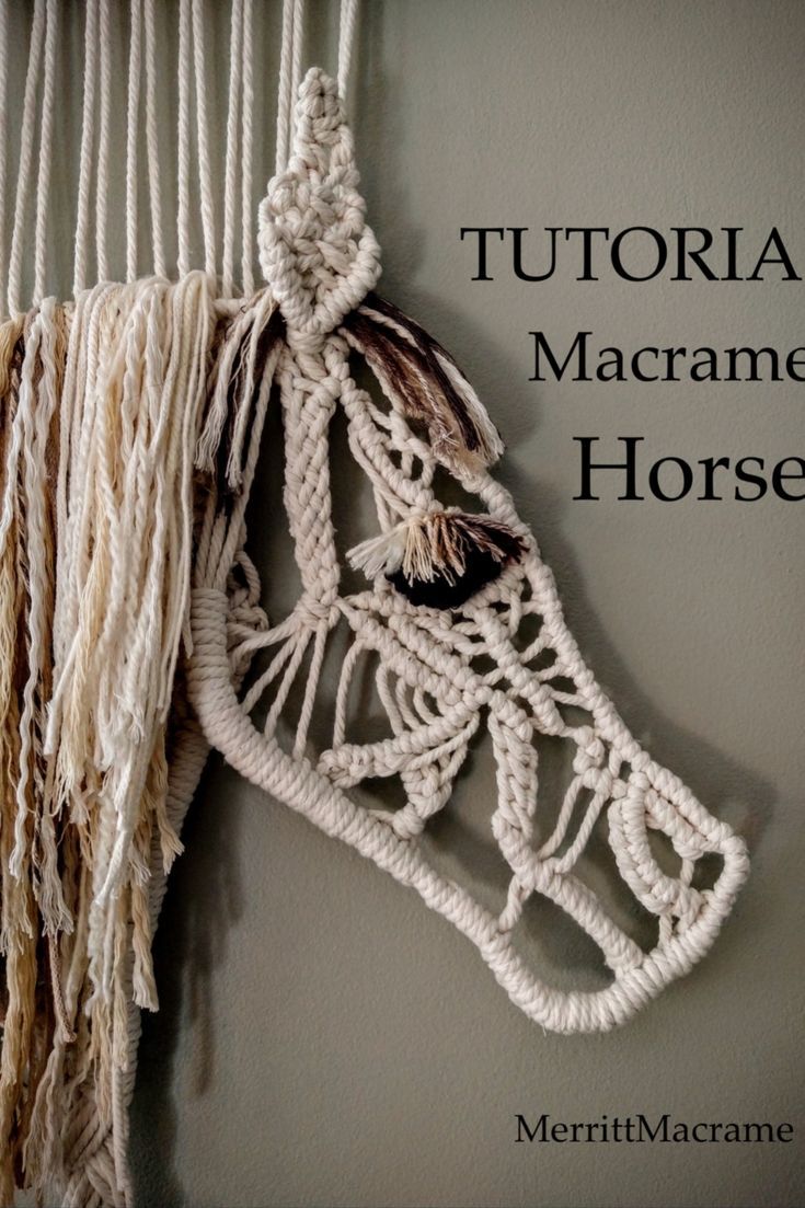 a white horse head hanging on the wall with macrame rope attached to it