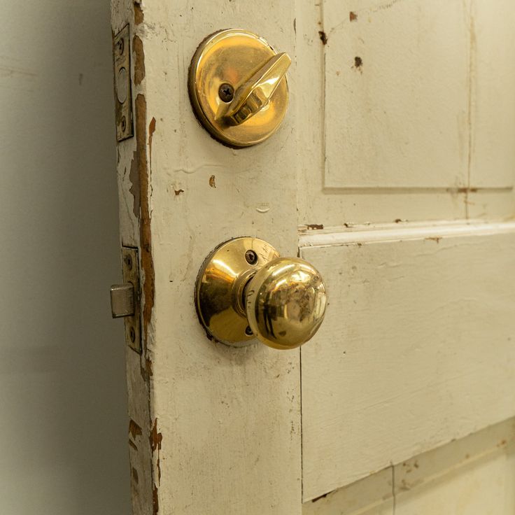 an old door with two knobs on the front and one has a gold handle