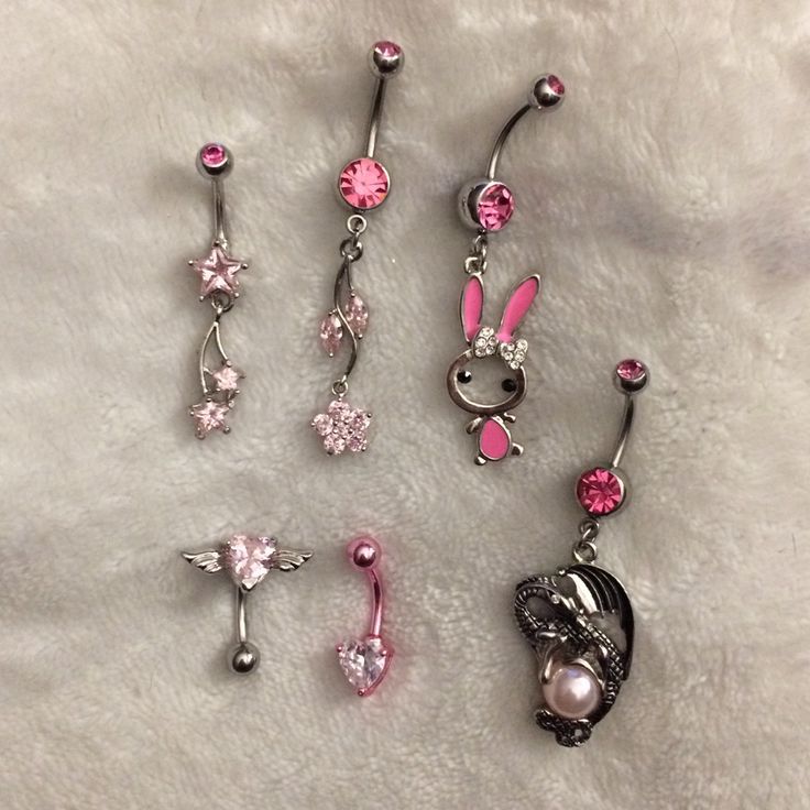 four different types of belly piercings on a white sheet with pink and silver beads