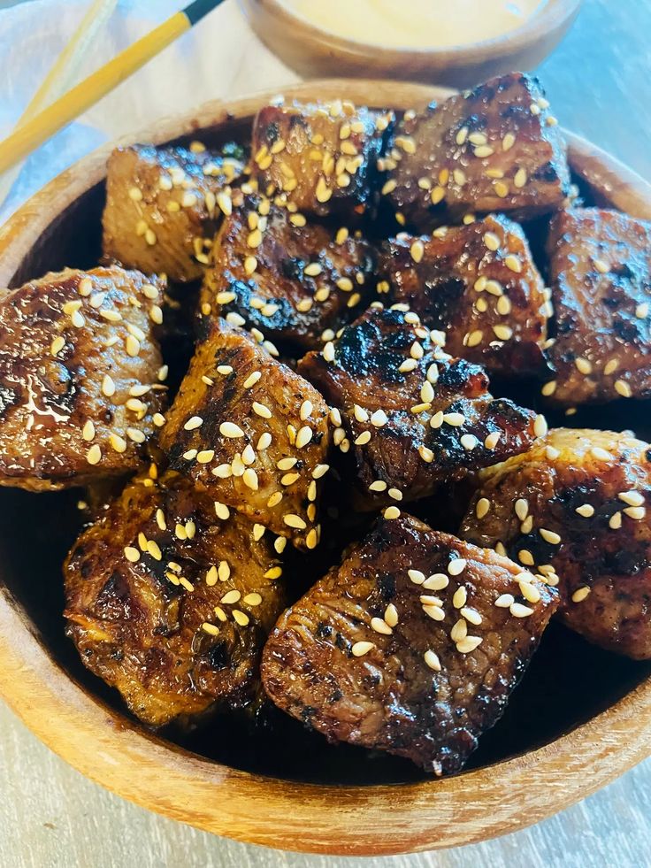 a wooden bowl filled with tofu and sesame seeds