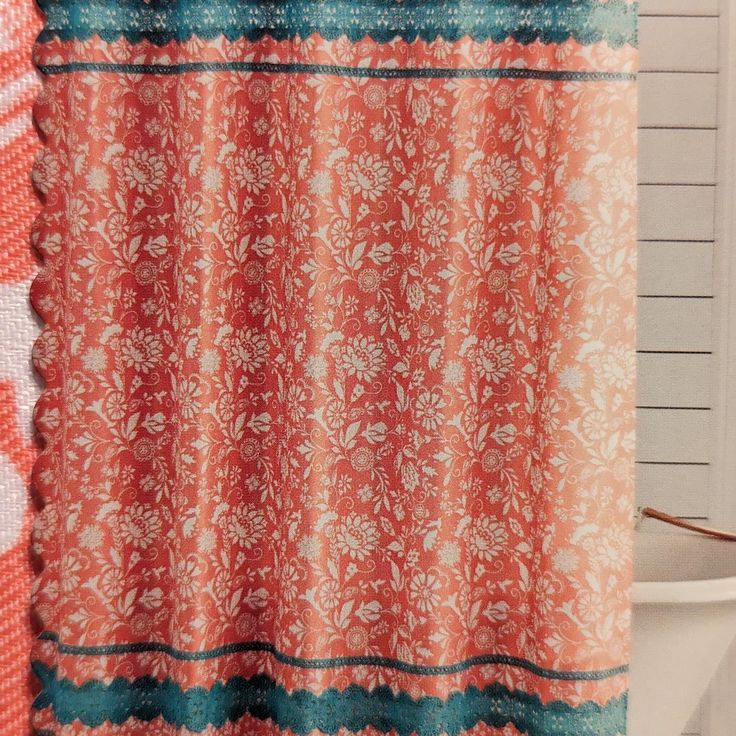 an orange and blue shower curtain in a bathroom with a white toilet next to it