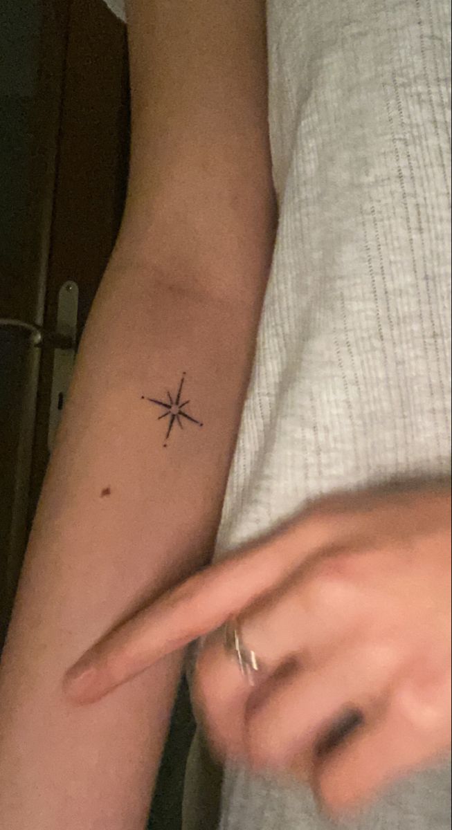 a person with a small star tattoo on their arm