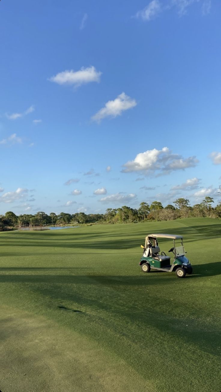 a golf cart driving across a green field