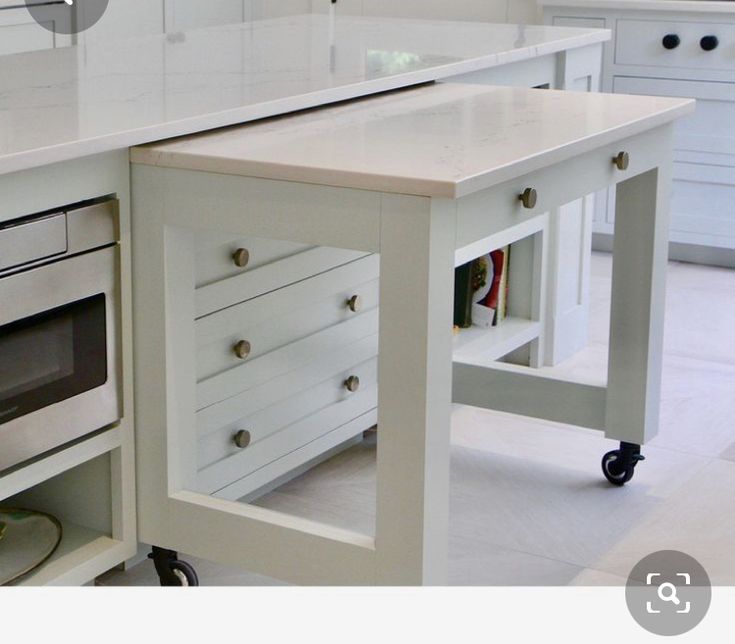 a white kitchen island with drawers underneath it