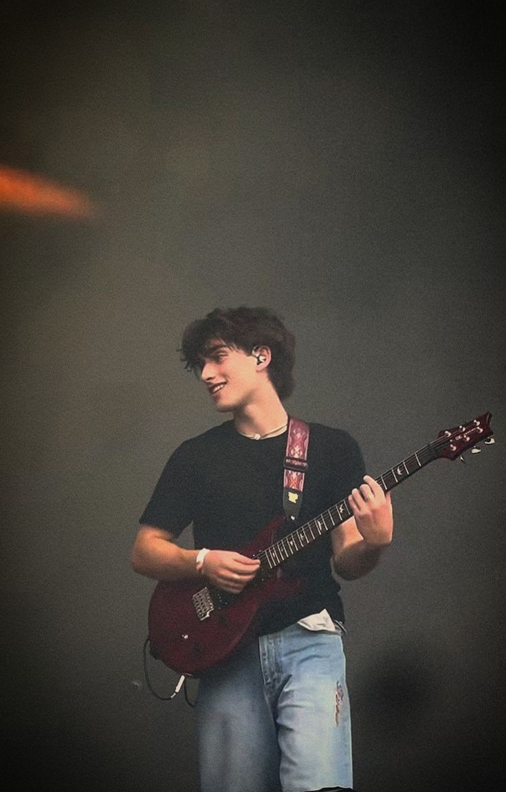 a young man is playing an electric guitar