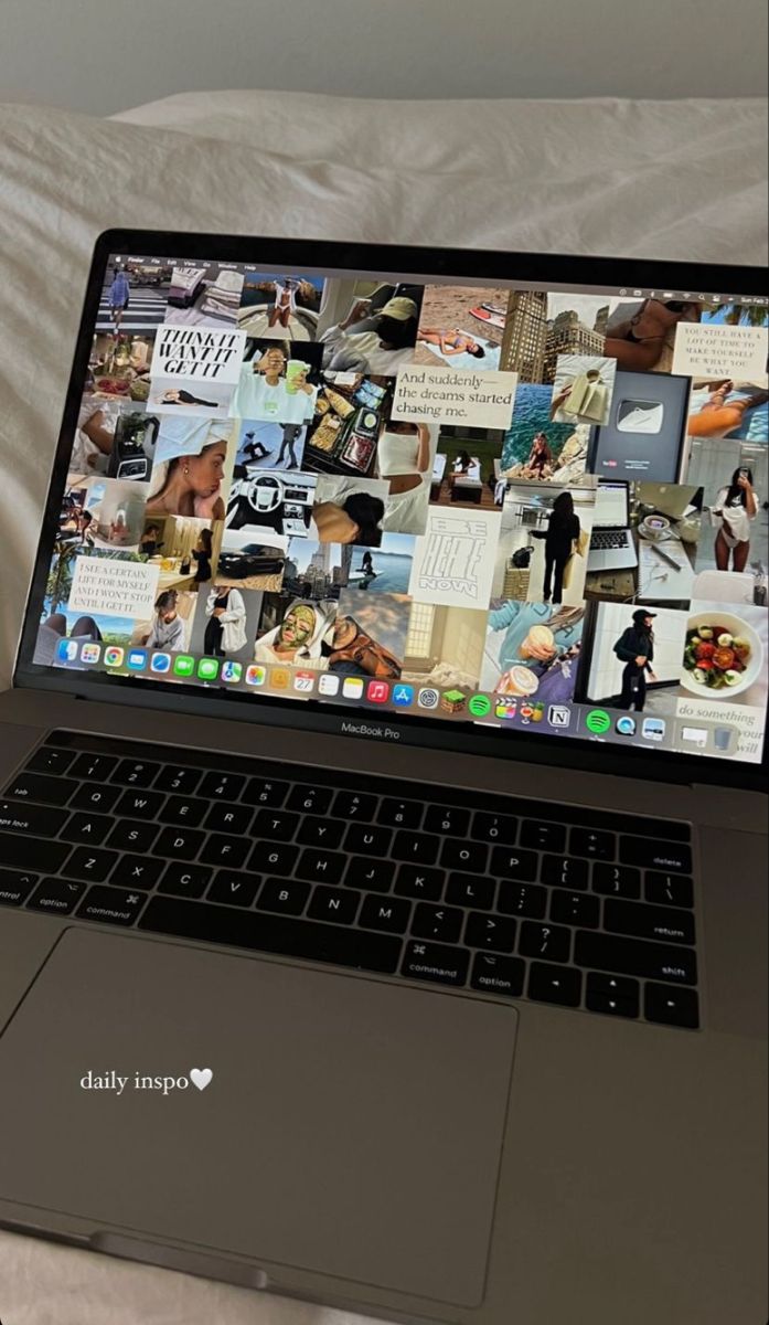 an open laptop computer sitting on top of a bed next to a white comforter