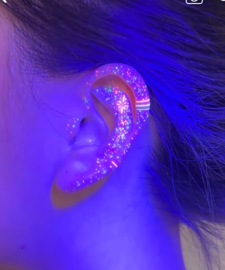 a woman with ear piercings that are glowing in the dark