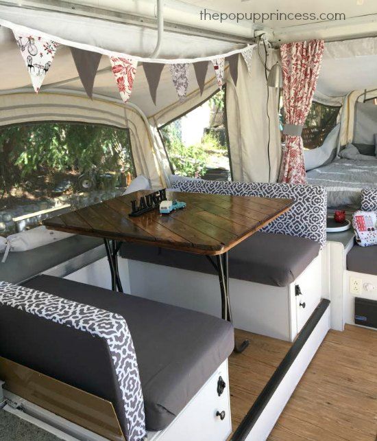 the inside of a camper with two couches and a table in front of it