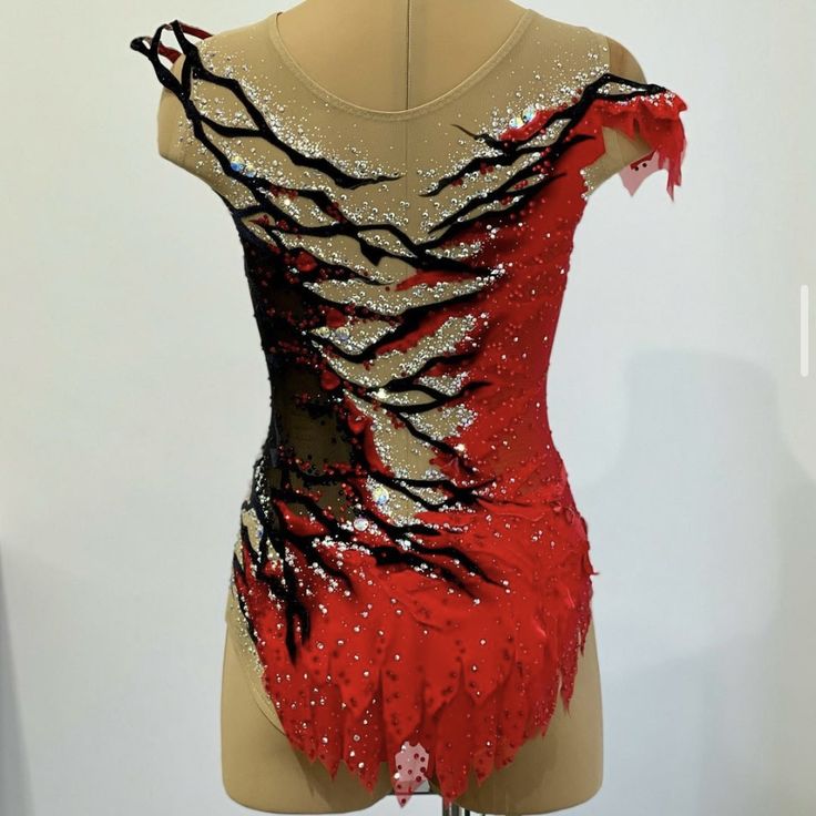 a mannequin wearing a red and black dress with sequins on it