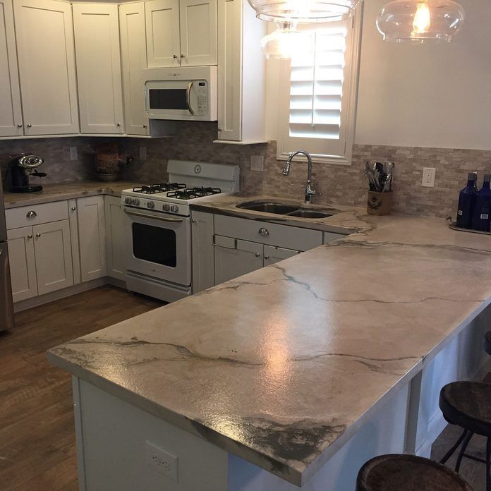 a kitchen with marble counter tops and white cabinets