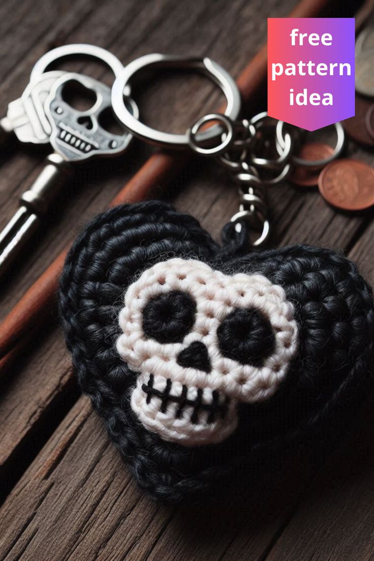 a crocheted heart keychain with a skull on it and two keys