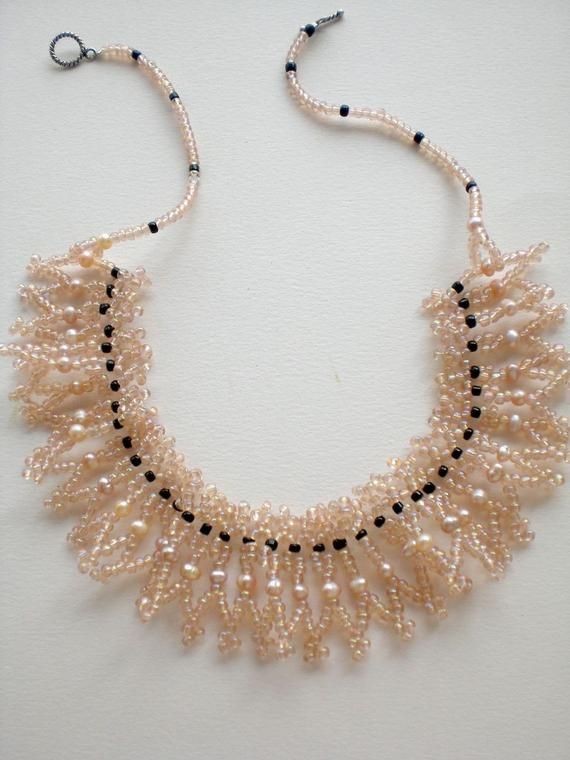 a beaded necklace with pearls and black beads