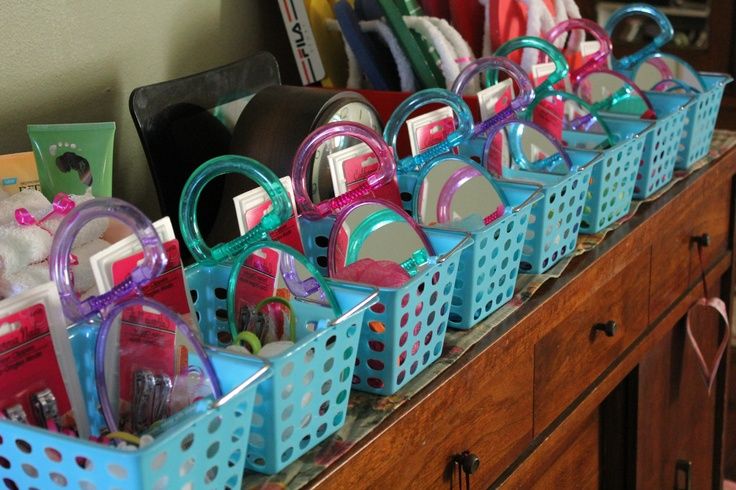 several blue baskets filled with various items on top of a wooden table next to a dresser