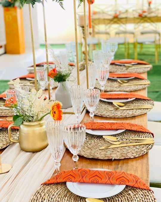 a table set up with place settings and flowers in vases on the top tables