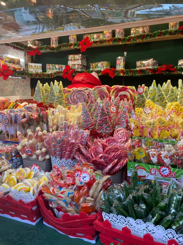 many different types of candies in baskets and on display at a christmas market stall