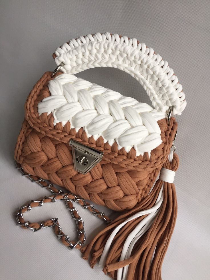 a brown and white purse with tassels on it