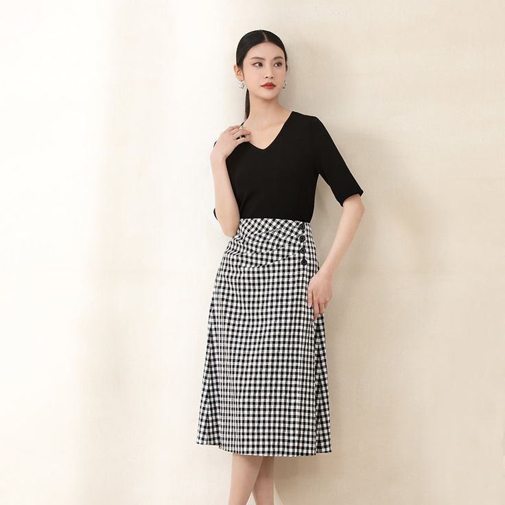 Crafted with a classic high-waisted silhouette and a flattering A-line shape, this skirt enhances the waistline for a proportionate look. The front panel features irregular three-dimensional tailoring and pleated structures, adding depth and dimension to the design while complementing the figure.The black and white checkerboard pattern, combined with the use of color-woven grids and salt shrinkage techniques, creates a subtle bubble texture on the surface, imbuing the skirt with a sense of fashion and sophistication. Chic A-line Skirt For Semi-formal Occasions, Chic Office Dress With Relaxed Skirt, Workwear Midi Dress With Pleated Waist, Chic Pleated Skirt With Fitted Waist, Chic Knee-length Maxi Skirt For Office, Chic Asymmetrical Pleated Wrap Skirt, Chic Dress With Asymmetrical Gathered Skirt, Fitted Pleated Maxi Skirt For Work, Chic A-line Skirt With Pleated Waist