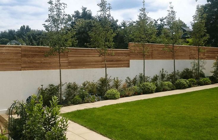 a fenced in yard with grass and trees