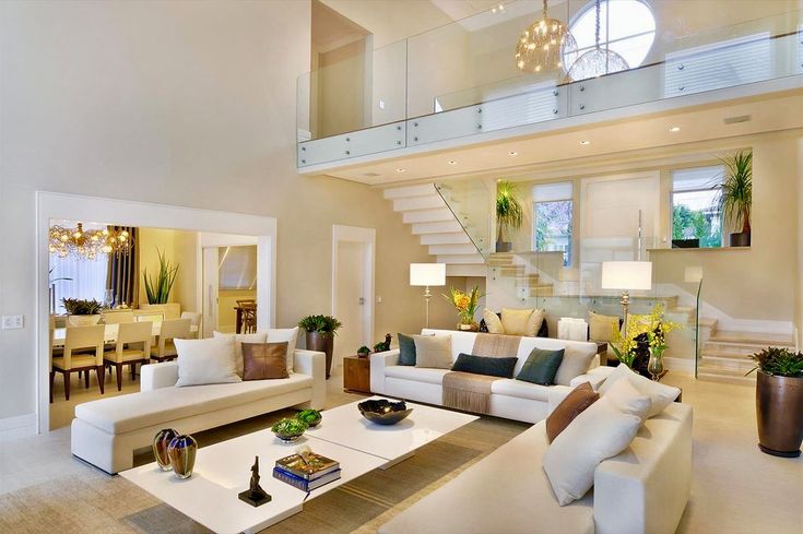 a living room filled with white furniture and lots of windows on top of the ceiling