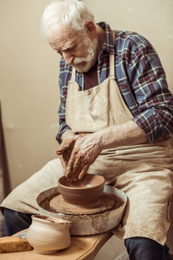 an older man is making a pot on a potter's wheel with his hands