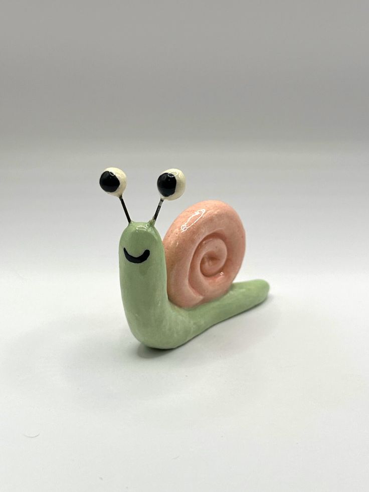 a small toy snail with two eyes on it's back and one eye closed