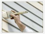 a person is holding a brush in front of a building's window sill