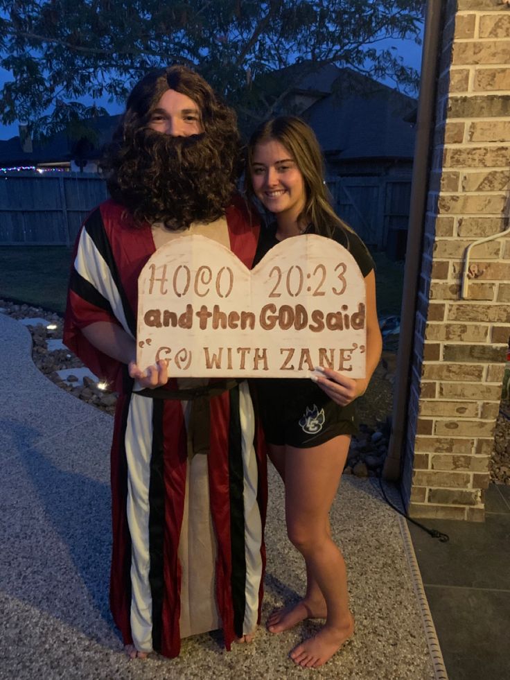 two people dressed up as jesus and mary holding a sign that says, hoco 2012 and then god said go with zane