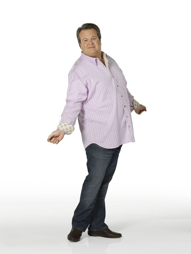 a man in a purple shirt and jeans is holding his hands out to the side