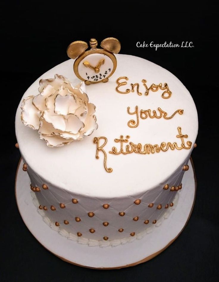 a white cake with gold lettering and a flower on top that says enjoy your retirement