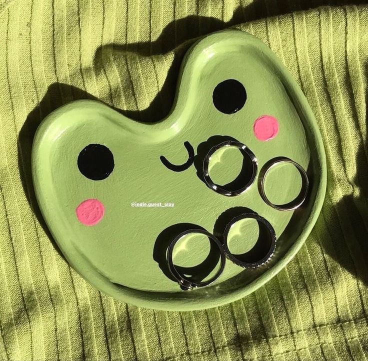 a green plate with black and pink polka dots on it sitting on top of a bed