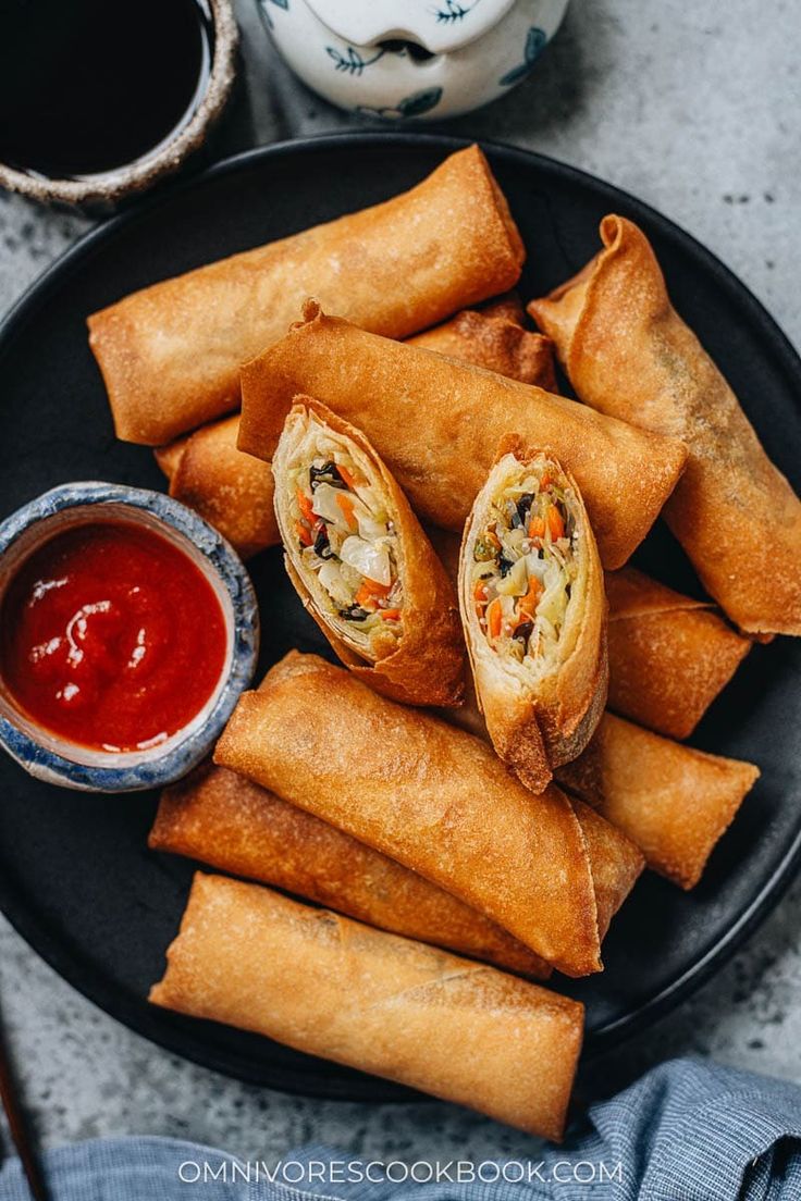 some food is on a black plate with dipping sauce