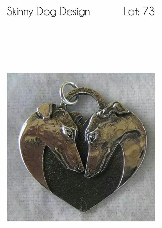 two silver horses head in the shape of a heart on top of a white background