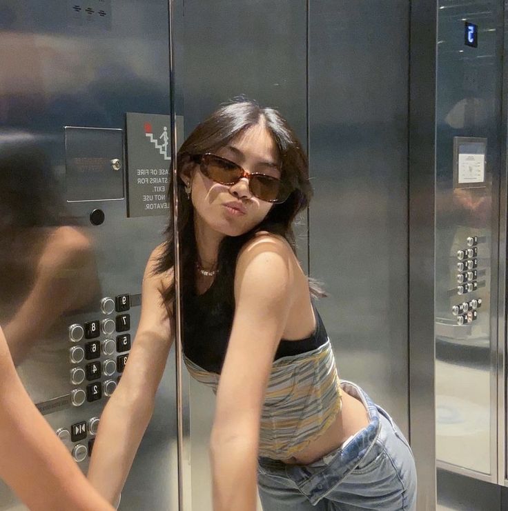 a woman is leaning against an elevator door