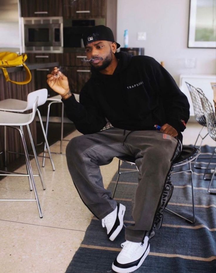 a man sitting on top of a chair in a kitchen