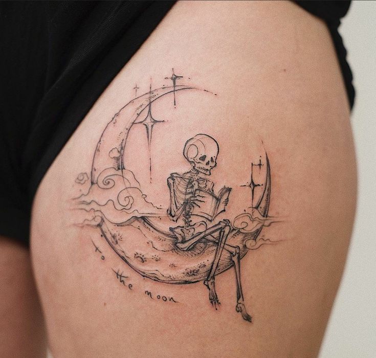 a woman with a skeleton tattoo on her thigh sitting on the moon and holding a cross