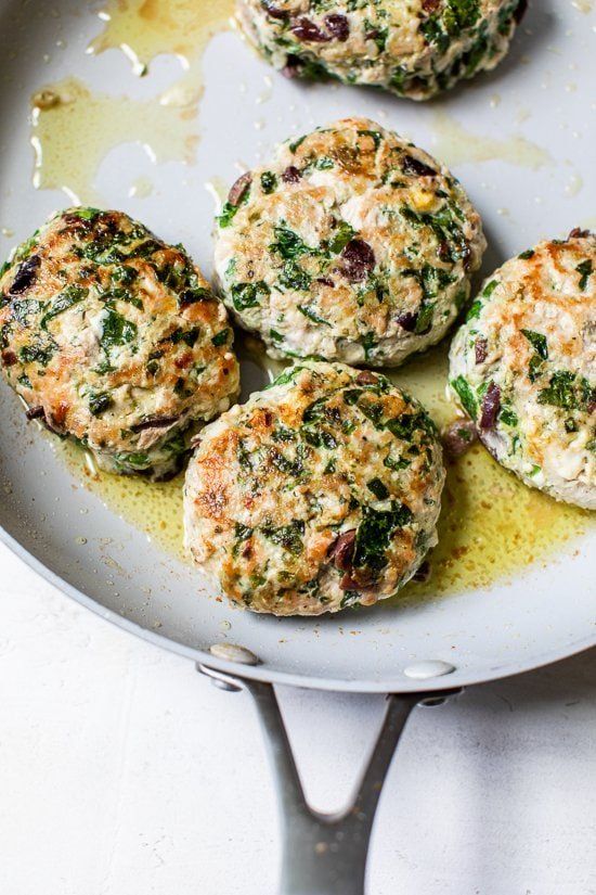 four crab cakes sitting on top of a white plate